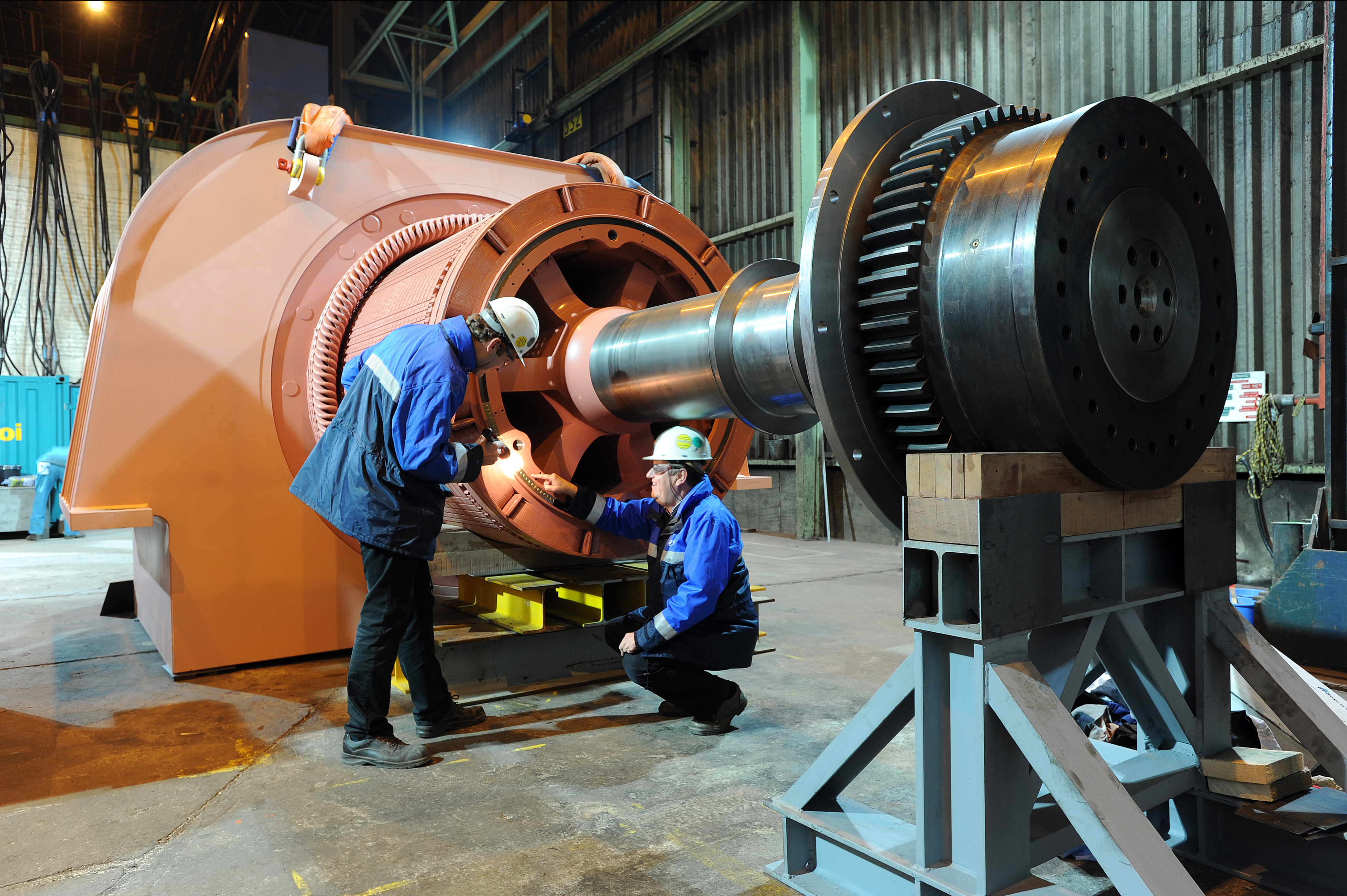 Kiwa employees inspecting a large industrial turbine rotor inside a manufacturing facility