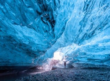 Man standing under a glacier