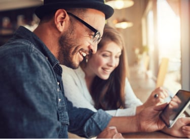 Male and female sitting behind a tablet