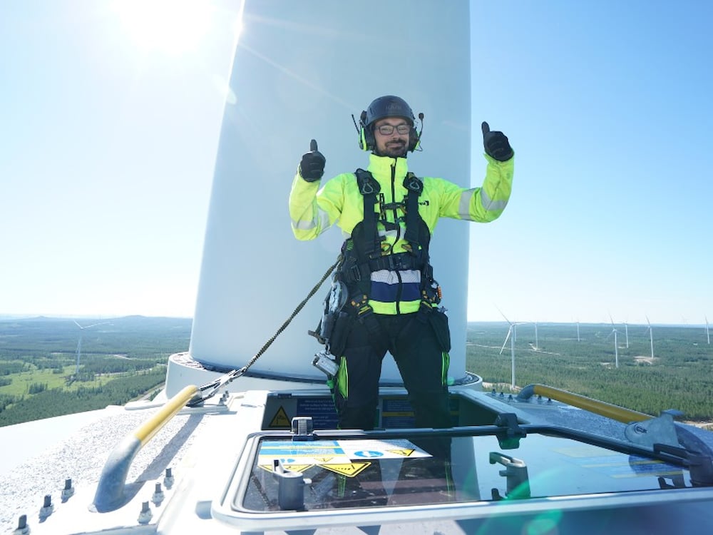 Kiwa inspector performing wind turbine inspecton giving two thumbs up while standing on the wind turbine