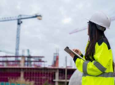 En byggingenjör ser ut över byggnadsställningar.