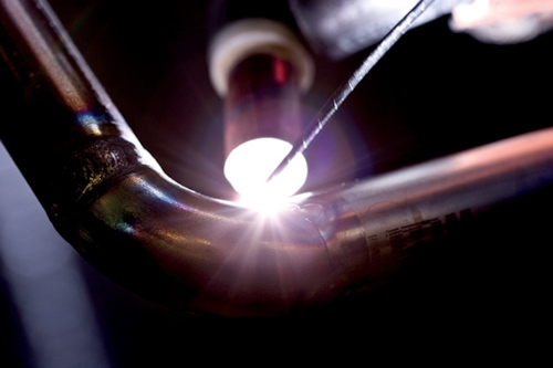 Närbild när svetsarbete görs på ett rör.