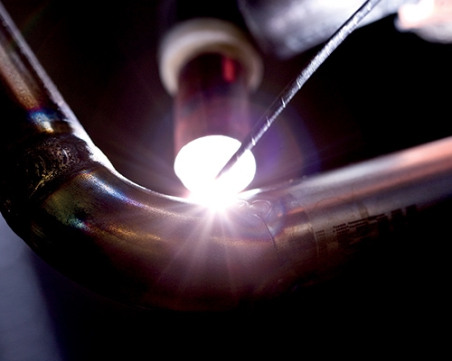 Närbild när svetsarbete görs på ett rör.