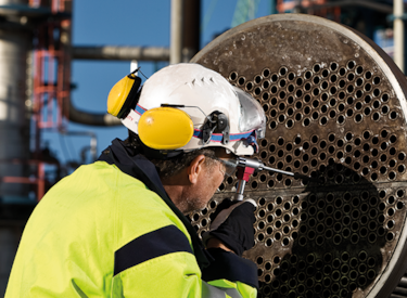 Kiwas besiktningsingenjör utför en kontroll av ett objekt på en industri.