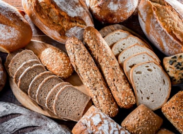 Different kinds freshly baked bread displayed on a table