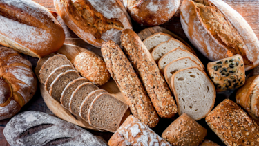 Different kinds freshly baked bread displayed on a table