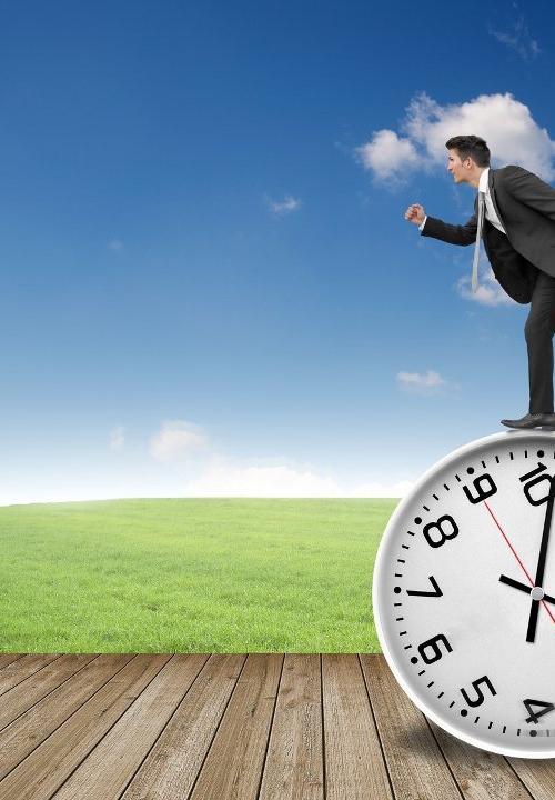 Businessman running on a large clock, symbolizing life time