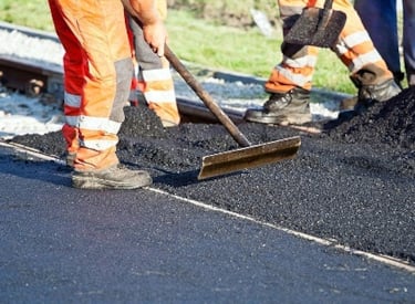 Road construction in operation with  workers paving a road with asphalt