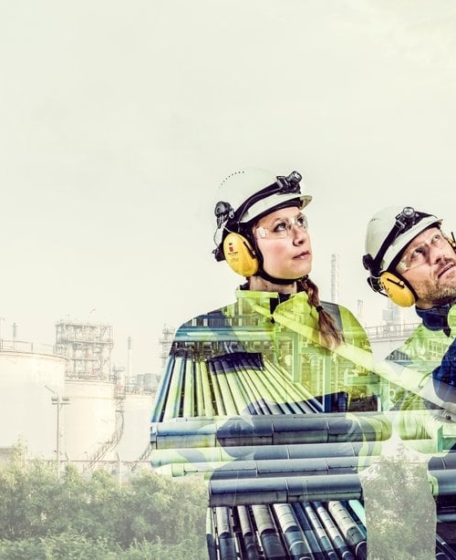 Kiwa eksperdid naine ja mees hoiavad kiivreid  käes ehitusplatsil