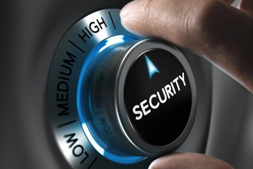 Hand draait aan een knop met opties "Low", "Medium" en "High", waarop "Security" staat aangegeven met een blauwe verlichting.