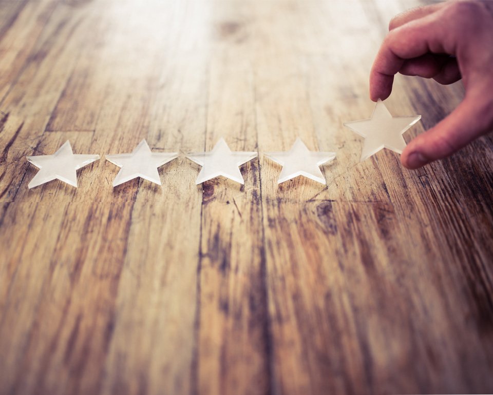 En gengrebild som visar en hand som lägger stjärnsymboler efter varandra på ett bord som exemplifierar metodisk process för att nå framgång. 