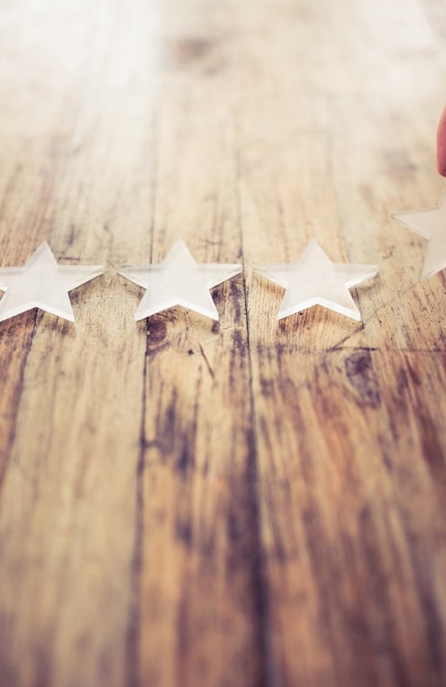 En gengrebild som visar en hand som lägger stjärnsymboler efter varandra på ett bord som exemplifierar metodisk process för att nå framgång.