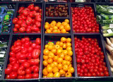 Flera olika tomater i en butikshylla.