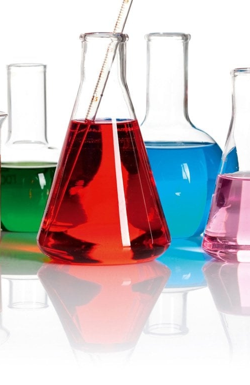 Vätskor i flera olika färggranna färger i olika typer av laboratorieflaskor.
