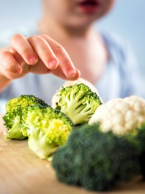 Child takes broccoli florets