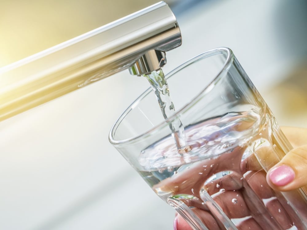 Tapping a glass of water in the kitchen