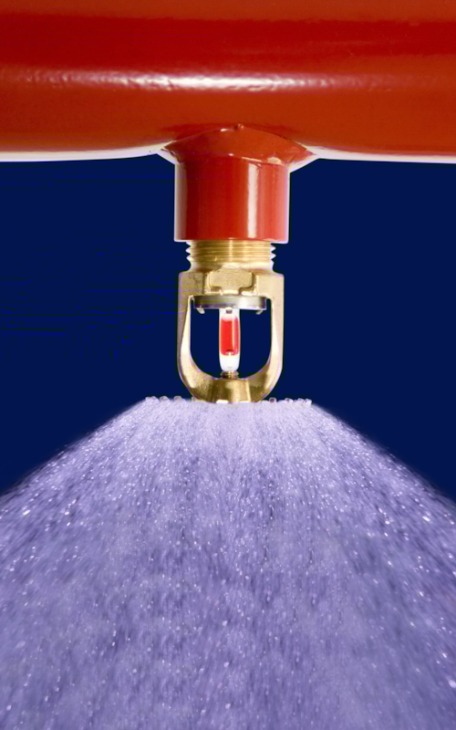 Närbild på en sprinkler som sprutar vatten.