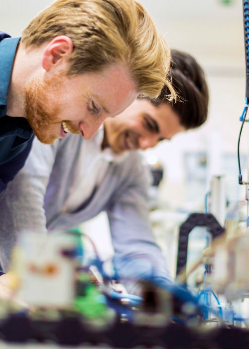 Two Kiwa engineers working together on a machine in a lab