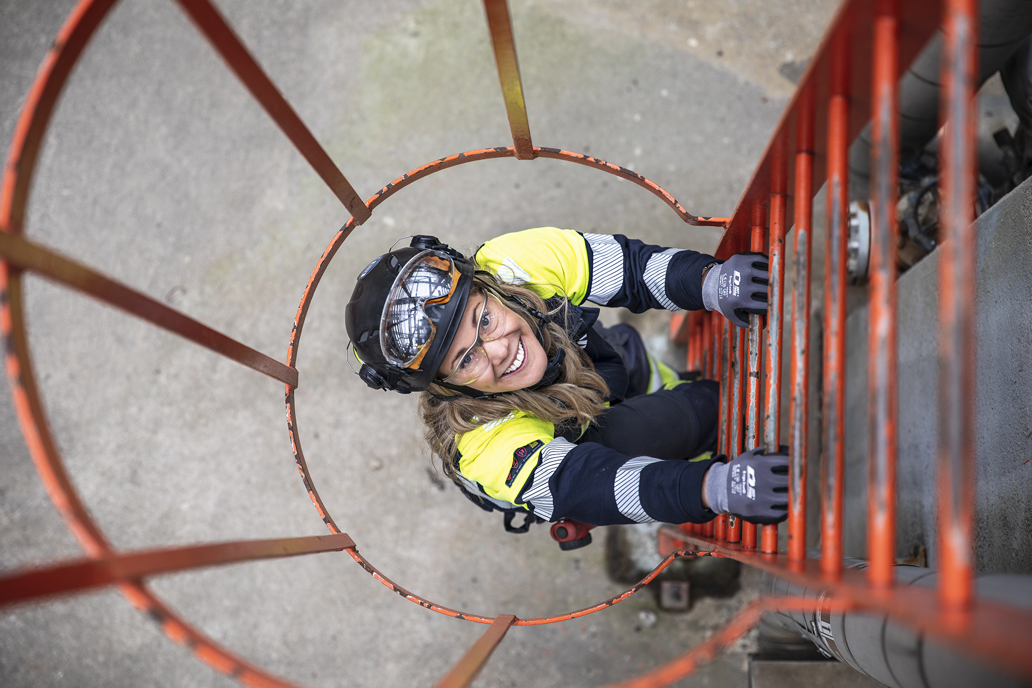 Female Kiwa inspector climbing up a ladder during a audit