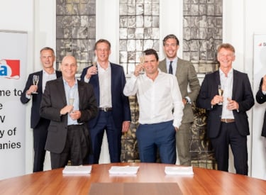 SHV and Kiwa representatives holding up a glass of champagne to celebrate their collaboration