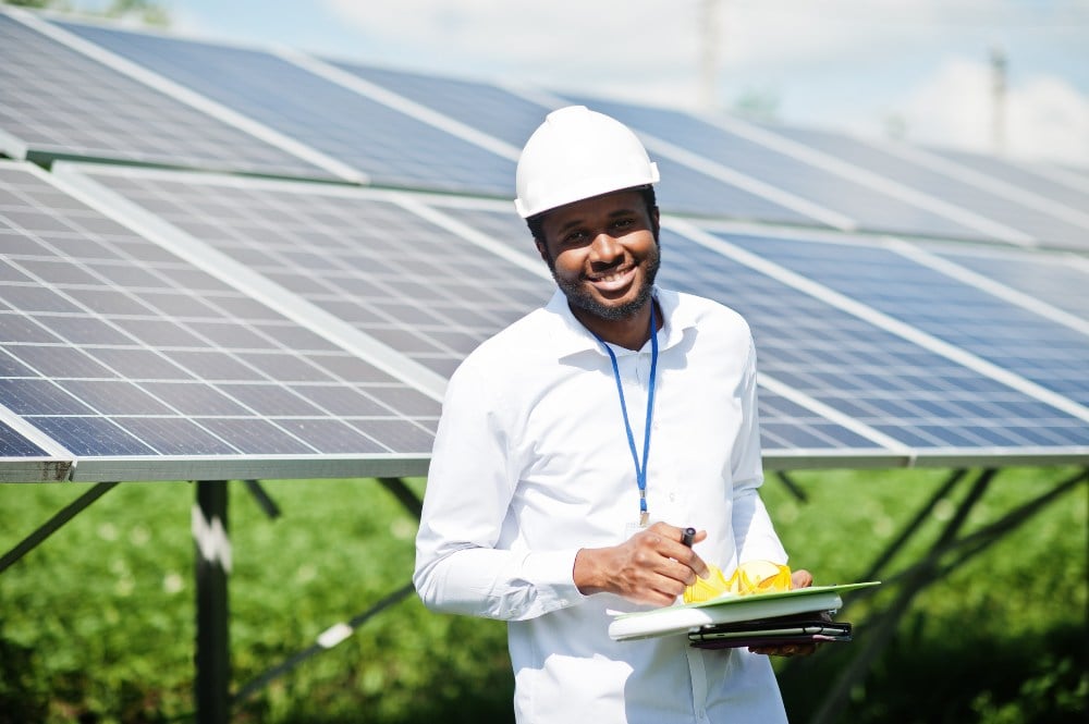 Kiwa consultant wearing a safety hat standing in a solar field during his consultancy round