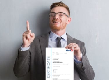 Kiwa employee dressed up in a suite holding a Kiwa certificate