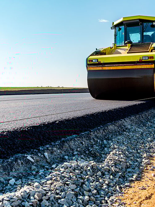 En vägvält körs på en nyasfalterad väg.