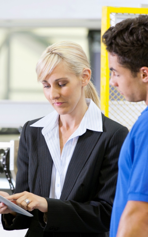 young woman assisting a male employee in a factory