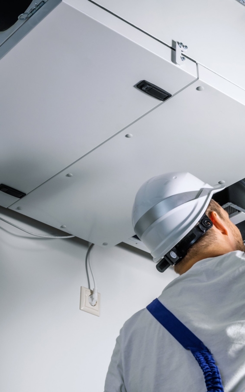 Besiktningsingenjör undersöker ventilationen i taket.