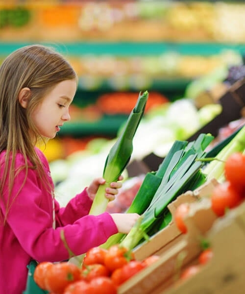 Child in the vegetable department in the supermarket