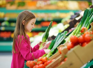 Child in the vegetable department in the supermarket