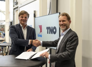 Ronald Karel van Kiwa en Peter Rasker van TNO schudden handen voor samenwerking op het gebied van warmtepompinstallaties