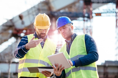 Two men discussing plans at construction site