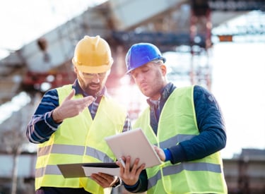 Two men discussing plans at construction site