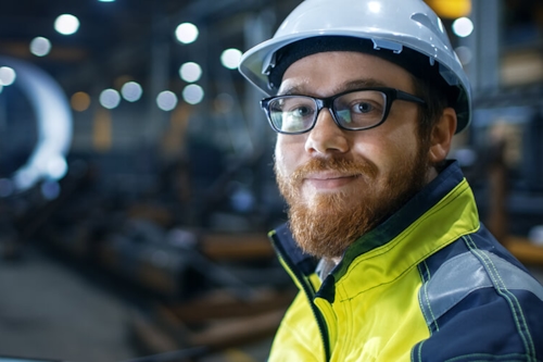 Employee with helmet looking friendly into the camera