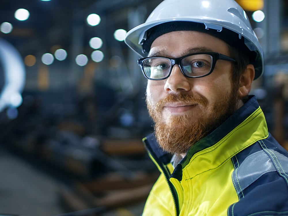 Employee with helmet looking friendly into the camera