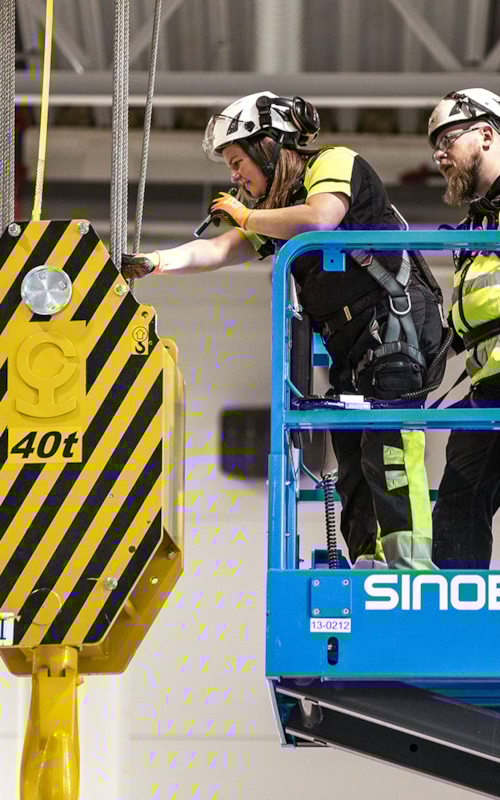 Två besiktningsingenjörer inspekterar en lyftkran.