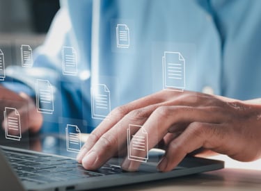 Digitalt arbete på en bärbar dator, händer som skriver på tangentbordet och symboler för dokument visas över bilden.