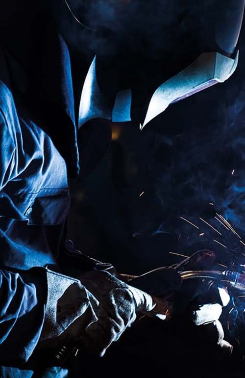 Svetsare svetsar på ett tryckkärl eller cisternliknande föremål.