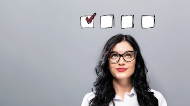 Kvinna funderar vilka krav som ska uppfyllas som illustreras genom ett antal checkboxar ovanför för hennes huvud. .