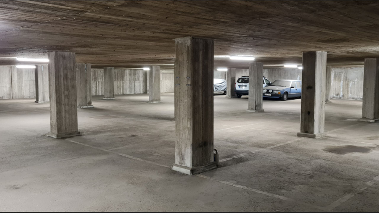 Garage med betonggolv och betongpelare.