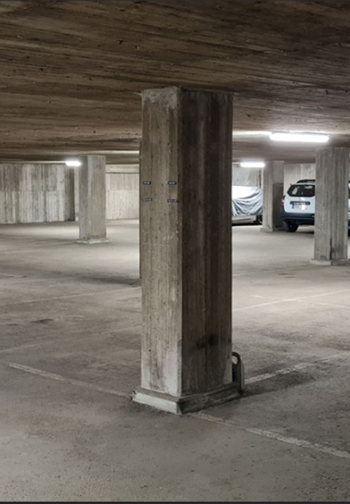 Garage med betonggolv och betongpelare.