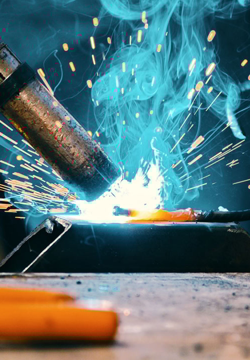 Närbild på svets under svetsarbete, glödgad metall.