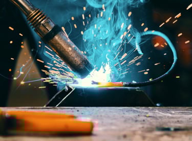 Närbild på svets under svetsarbete, glödgad metall.