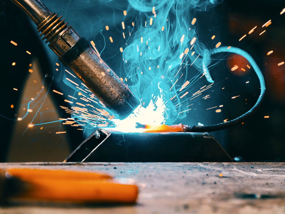 Närbild på svets under svetsarbete, glödgad metall.