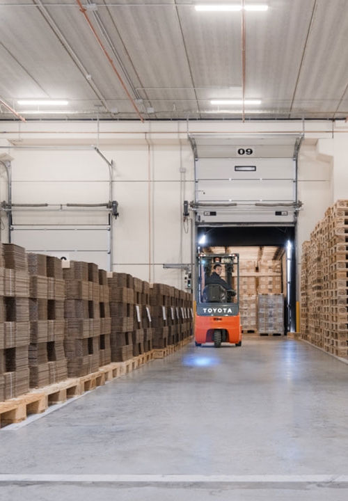 Två truckförare arbetar i ett lager och lastar en lastbil.