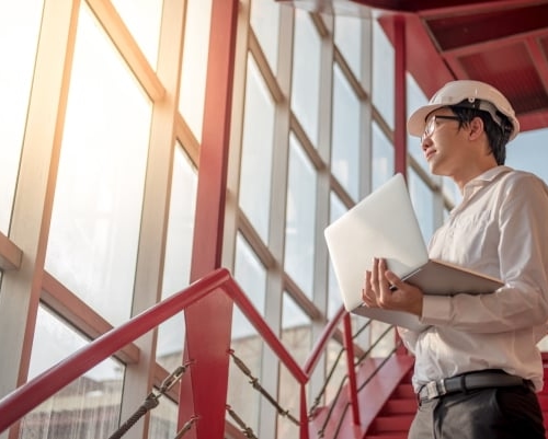 Kiwa töötaja kiivriga vaatamas aknast välja