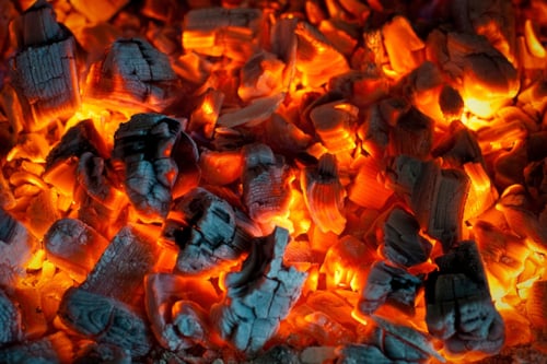 Glowing hot charcoal embers in a fire pit