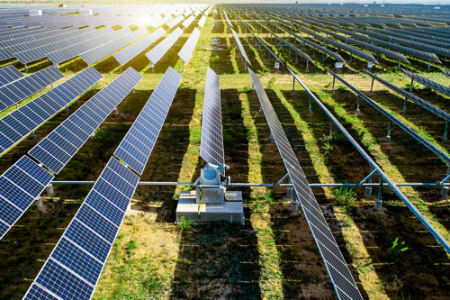 long grass field with countless solar pannels taking part in a batch testing session