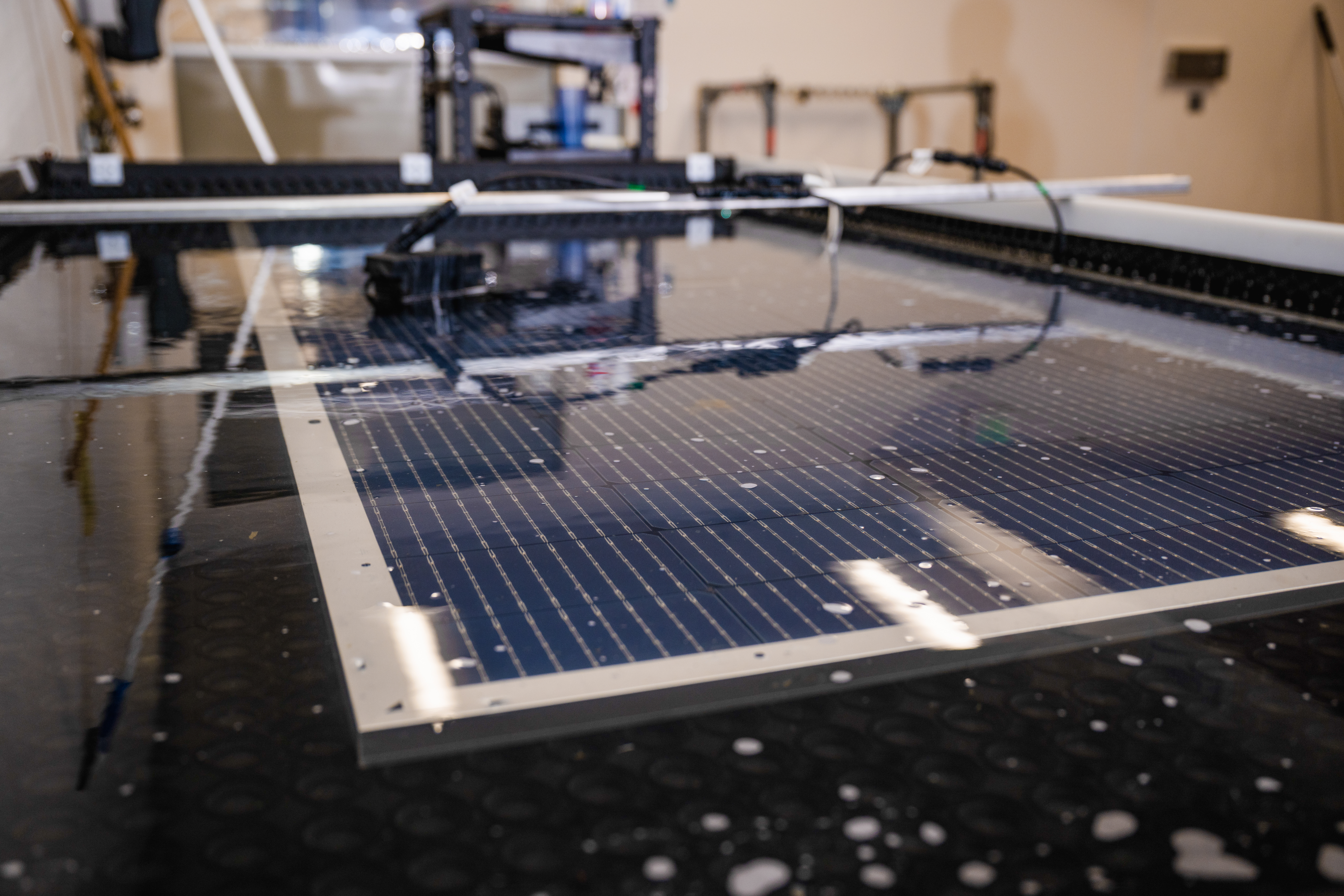 Solar panel undergoing testing with water drops on its surface in a laboratory setting